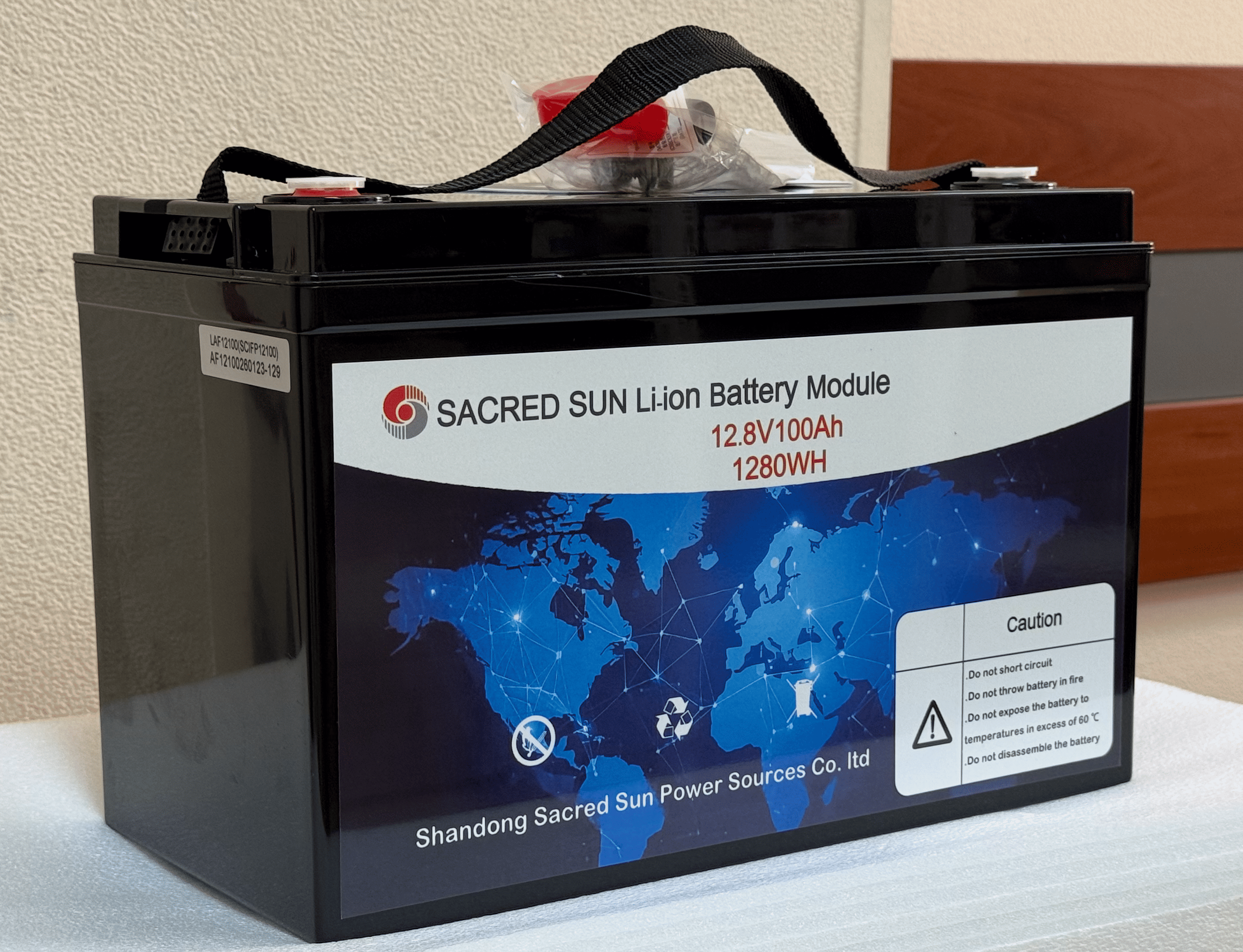 Аккумулятор Sacred Sun SCIFP12100 слева спереди, маркировка модели и разъём BMS